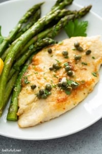 close up of chicken piccata on plate with roasted asparagus