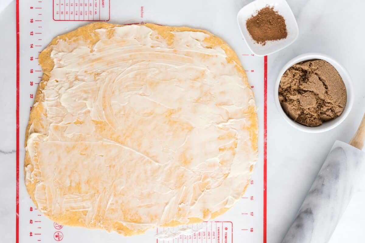 Spreading butter over the rolled out dough.