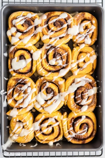 overhead of pan with pumpkin cinnamon rolls with icing