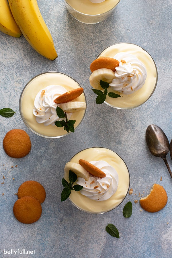 overhead of 3 parfait glasses filled with pudding and topped with whipped cream