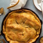 overhead of double crusted baked apple pie in cast iron skillet