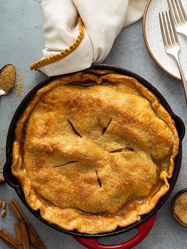 overhead of double crusted baked apple pie in cast iron skillet