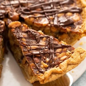 close up of slice of turtle pie drizzled with chocolate on serving spoon
