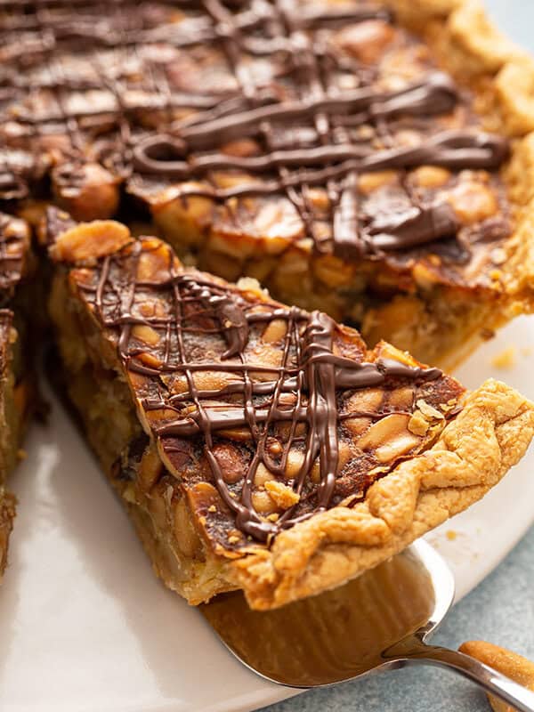 close up of slice of turtle pie drizzled with chocolate on serving spoon