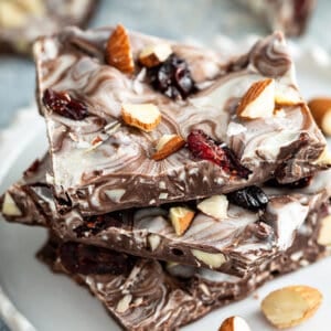 3 pieces of almond chocolate bark stacked on white plate