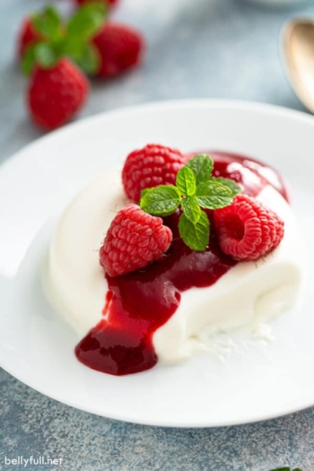 panna cotta with raspberry sauce and fresh mint leaves