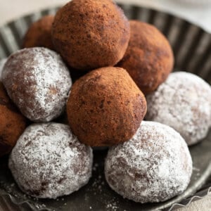 stack of rum balls coated in powdered sugar and cocoa powder