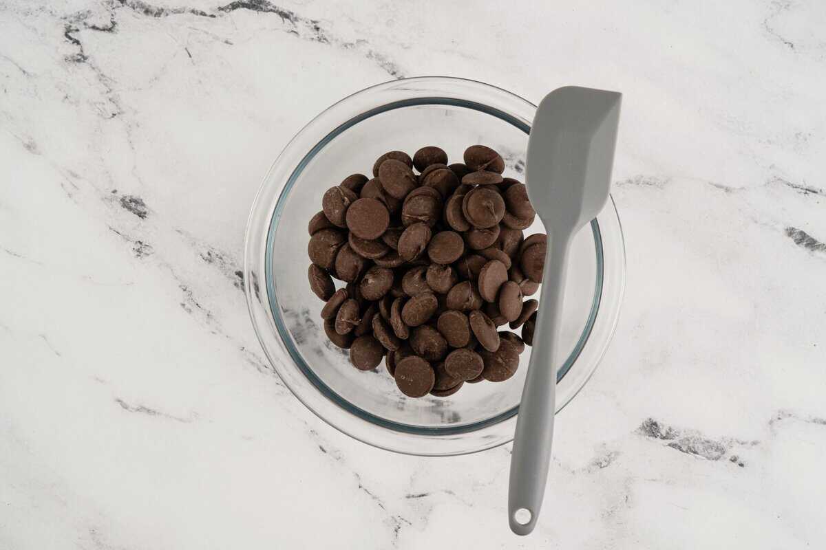 Chocolate melts in a glass bowl with a spatula.