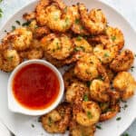 overhead picture of air fryer coconut shrimp on plate with dipping sauce