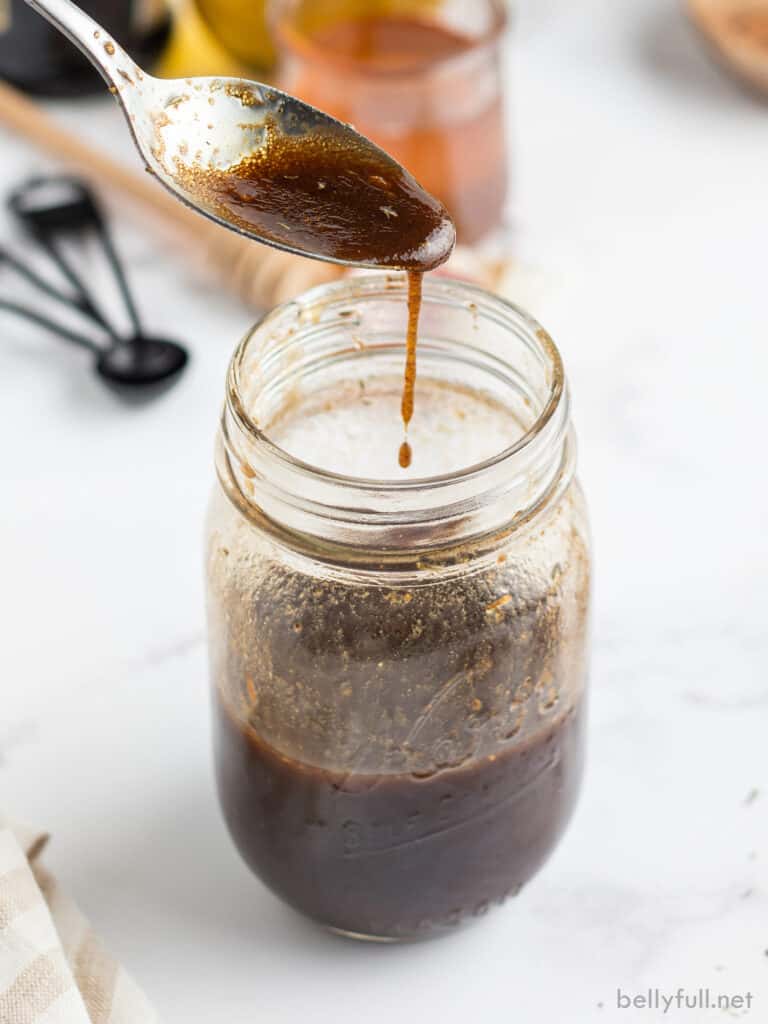 Balsamic Vinegar Dressing dripping off of spoon into jar