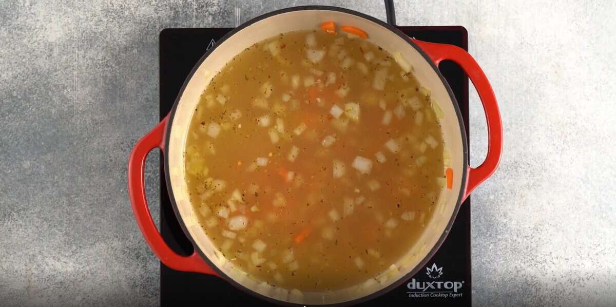 Adding chicken broth to the pot.