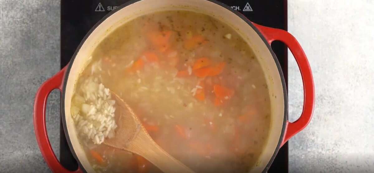 Adding the rice to the pot with the soup.