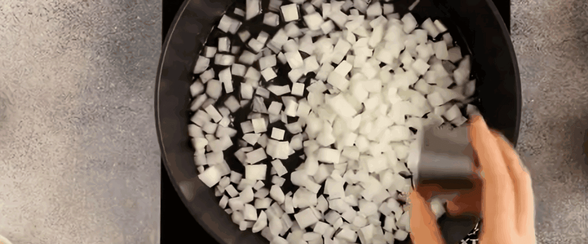 Cooking diced onions in a skillet. 