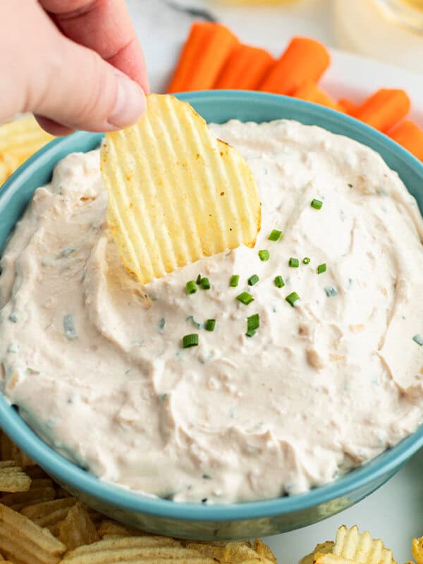 wavy potato chip being dunked into French Onion Dip