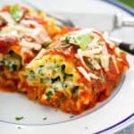 2 baked lasagna rolls ups on white plate