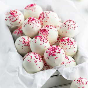 cake balls coated in white chocolate and pink sprinkles