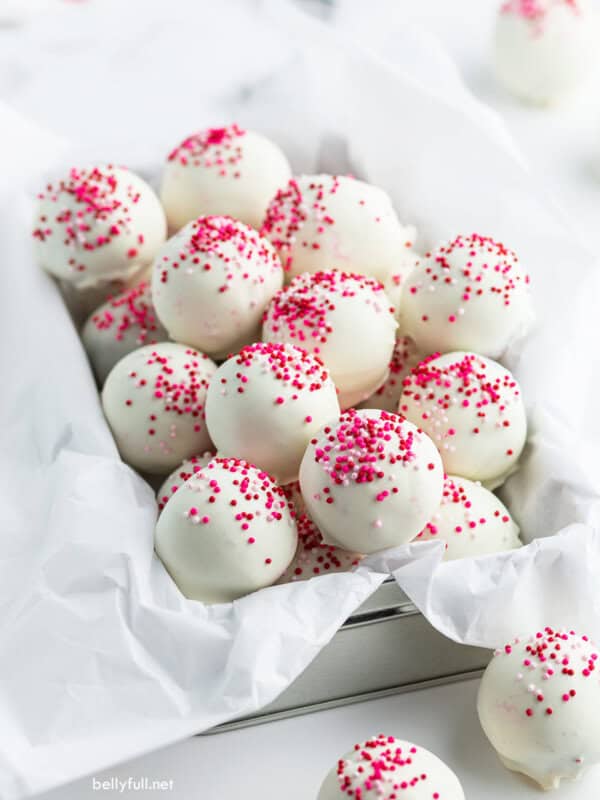 cake balls coated in white chocolate and pink sprinkles