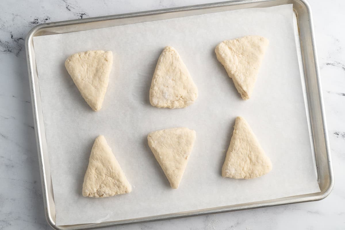 Scone dough on a parchment lined baking sheet.