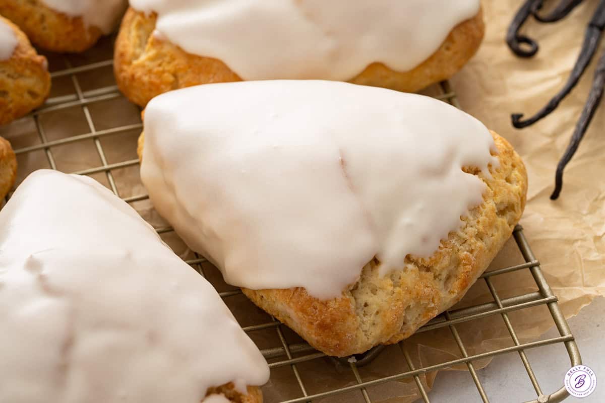 Baked and frosted scone on a cooling rack.
