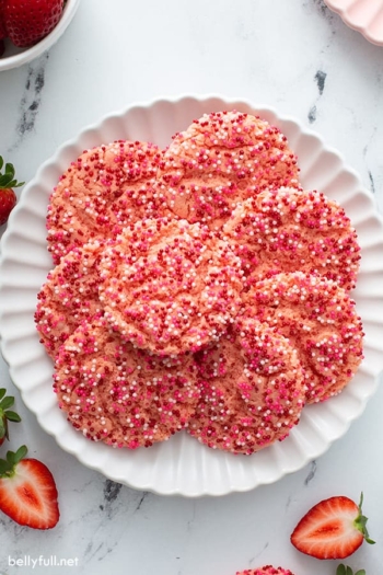 overhead of fanned strawberry cake mix cookies on white plate