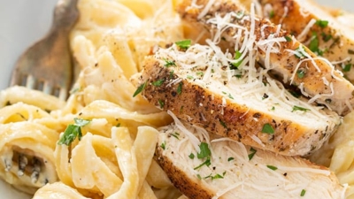 close up of chicken alfredo on white plate