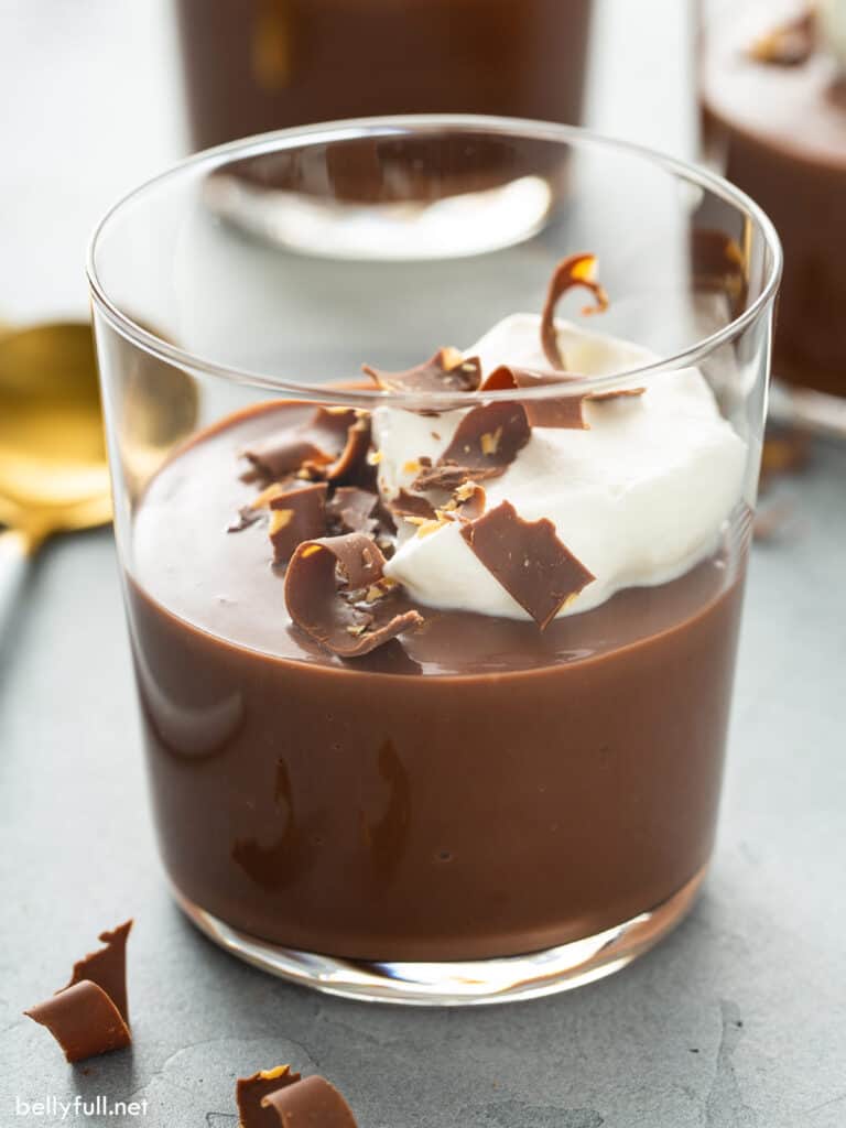 Chocolate pudding in a cup with whipped cream and chocolate shavings. 