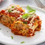 baked sausage lasagna rolls on white plate