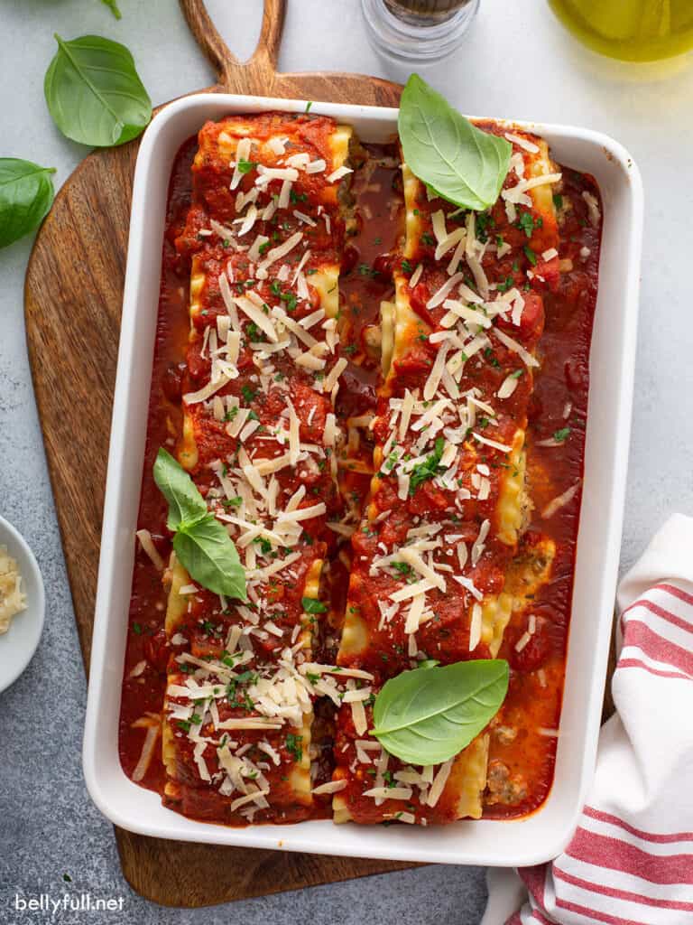 overhead baked sausage lasagna rolls in white casserole dish