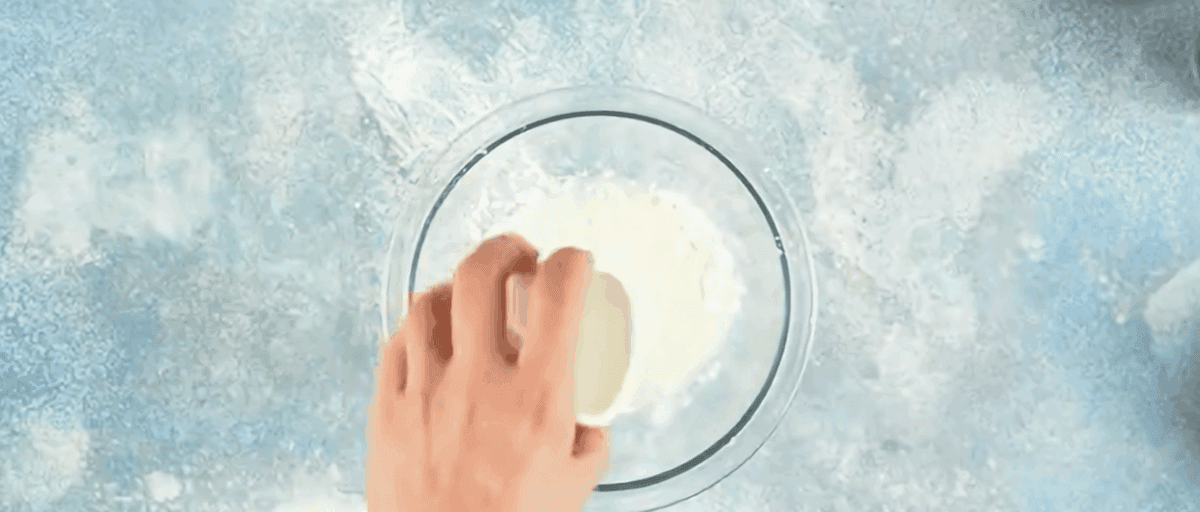 Combining cornstarch and water in a glass bowl.