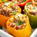 close up of stuffed peppers in white baking dish