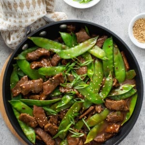 overhead beef stir fry with snow peas in skillet