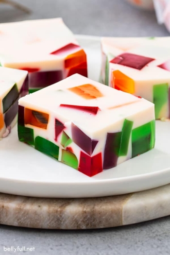 close up square of broken glass jello on white plate