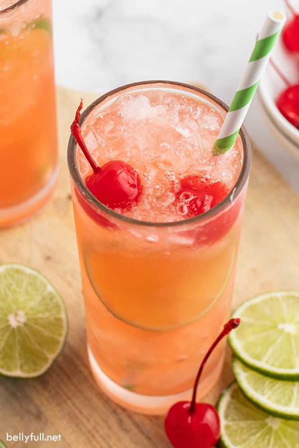 soda, crushed ice, and maraschino cherries in tall glass