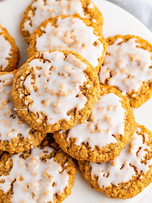 overhead picture stack of iced oatmeal cookies on white plate
