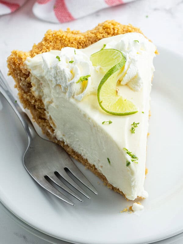 slice of key lime pie on white plate with fork