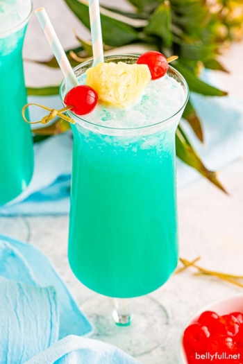 Blue Hawaiian drink in hurricane glass with pineapple garnish