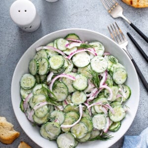 overhead picture of cucumber and onion salad in white serving dish