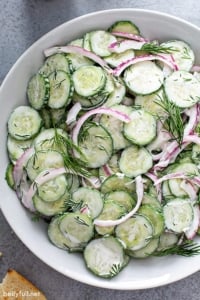 overhead picture of creamy cucumber salad in white serving bowl