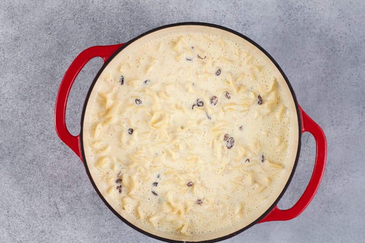 Custard, noodles, and raisins in a pot. 