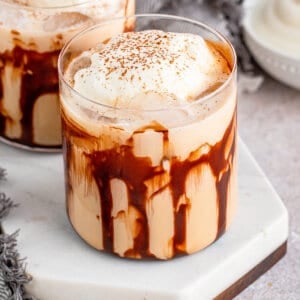 Mudslide cocktail garnished with whipped cream and cinnamon