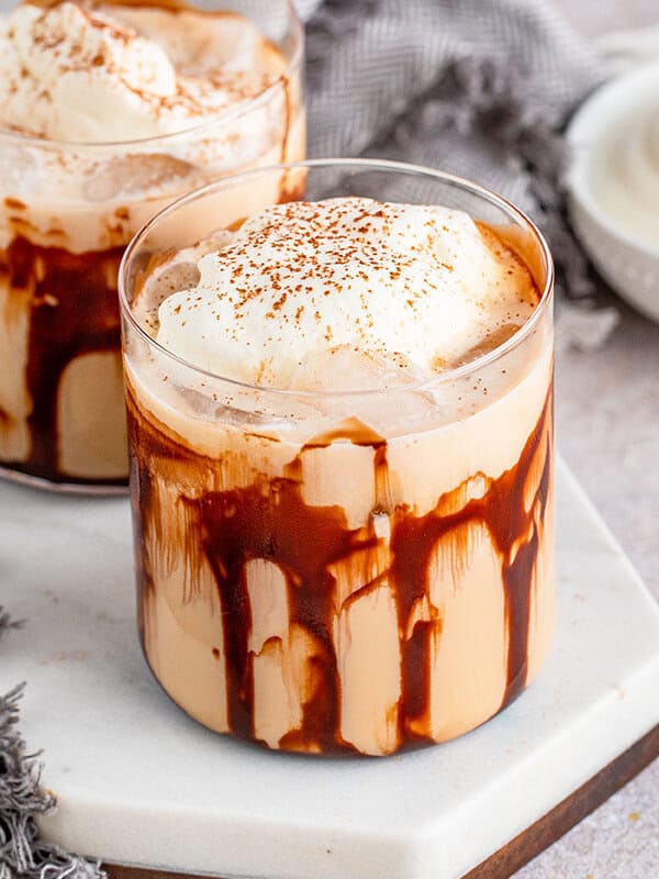 Mudslide cocktail garnished with whipped cream and cinnamon