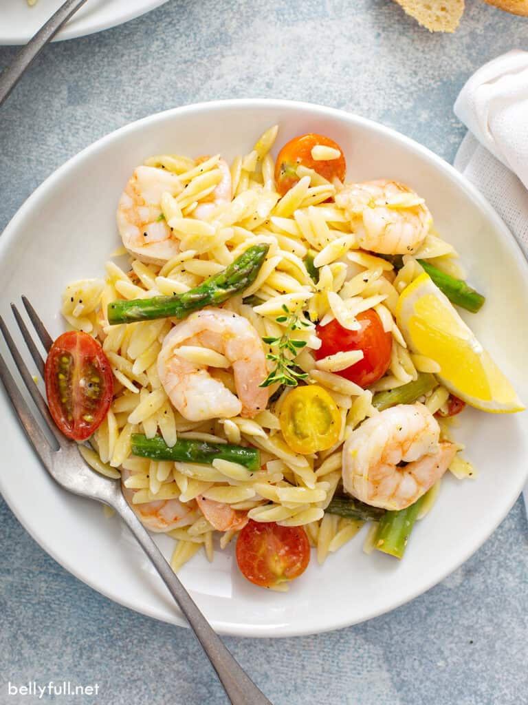 overhead of Orzo Pasta Salad with shrimp and asparagus on white plate