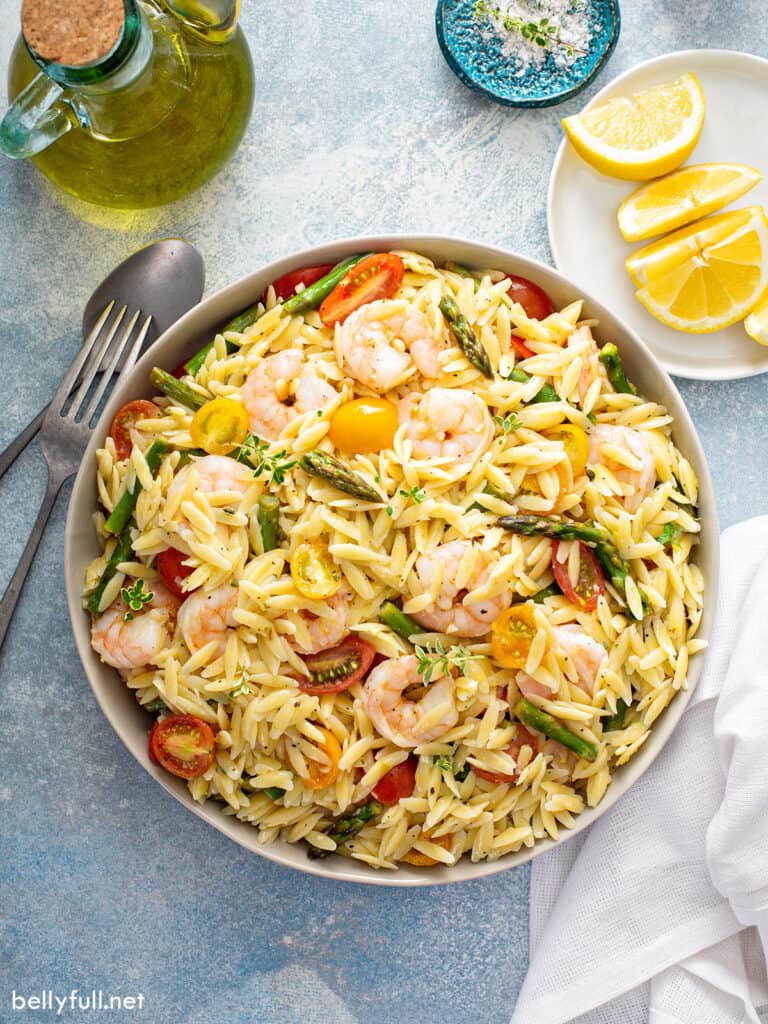 overhead of Orzo Salad with shrimp, asparagus, and tomatoes in serving bowl