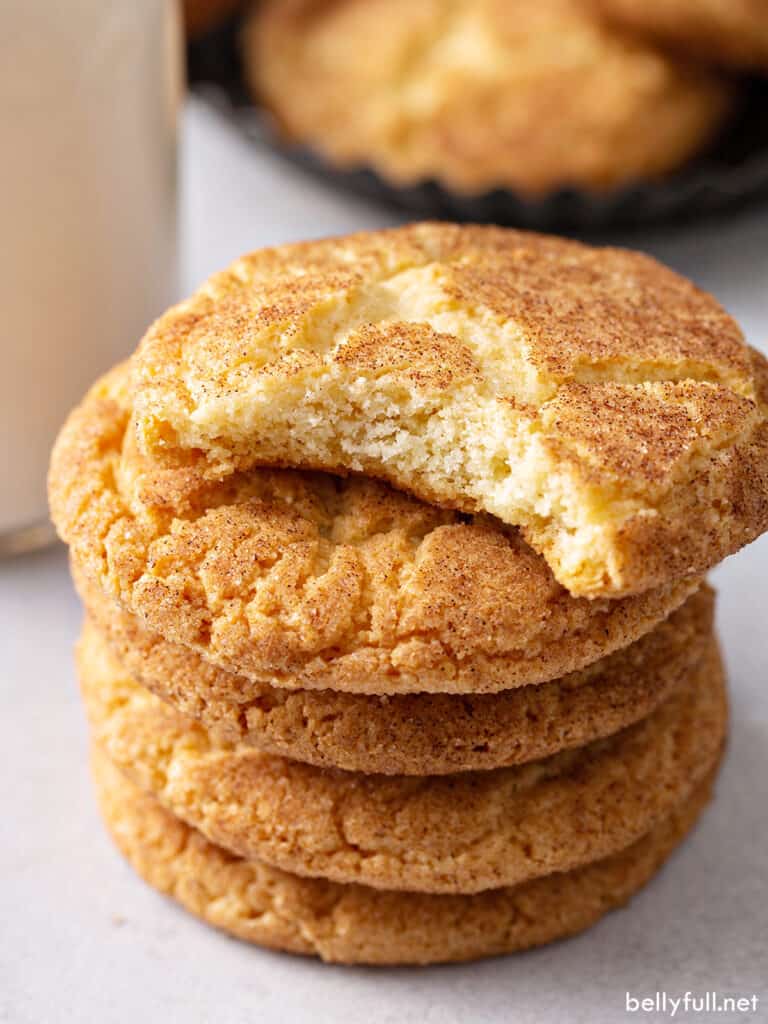 stack of 5 snickerdoodle cookies with bite out of top one