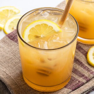 Bee's Knees drink with half moon lemon slice and honey drizzler