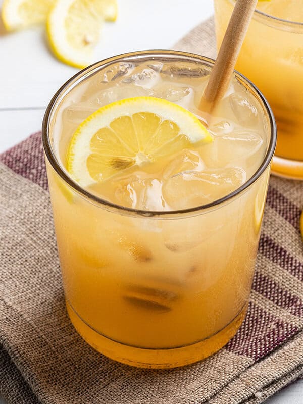 Bee's Knees drink with half moon lemon slice and honey drizzler