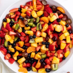 overhead summer fruit salad in white serving bowl