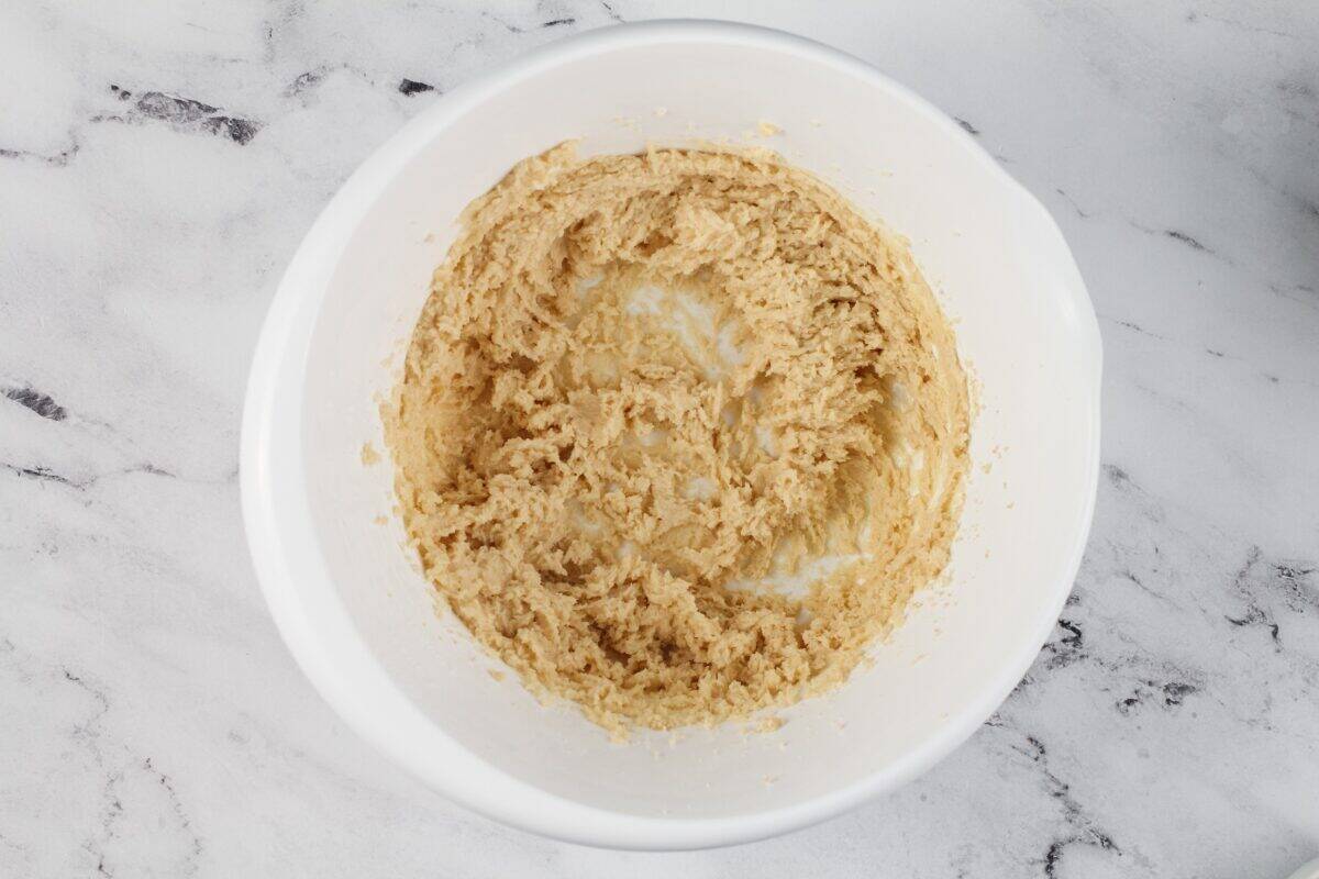 Creaming butter and sugar in a white bowl.