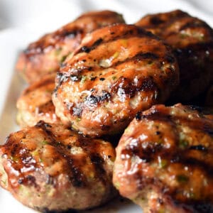 grilled pork sliders piled on white serving plate