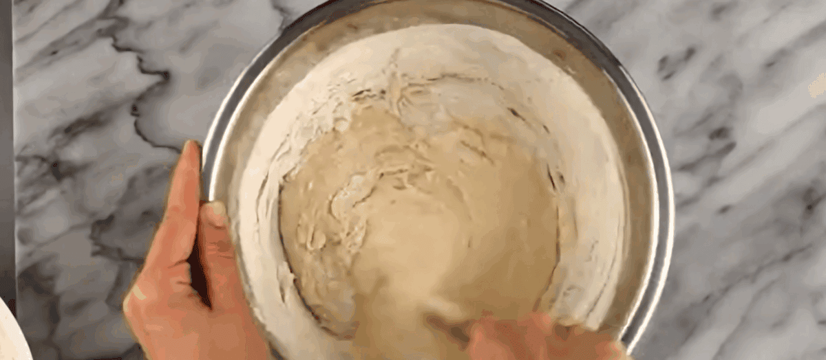 Adding the ingredients to make the dough to the yeast.